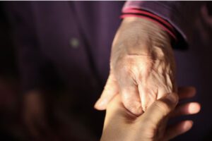 alzheimers man holding caregivers hands