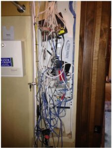 A wiring panel that has cables hanging outside the door.